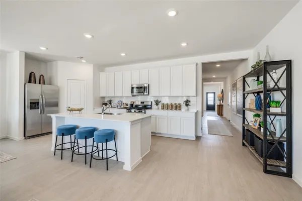 a kitchen with white cabinets and refrigerator