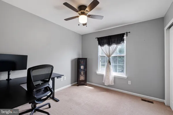 a view of a workspace with furniture and a window