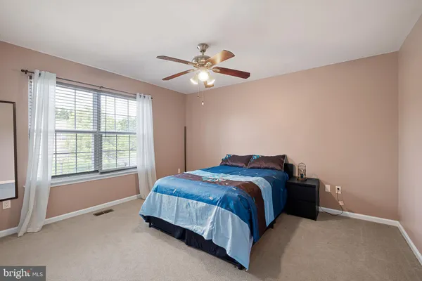 a bedroom with a bed and a ceiling fan in it