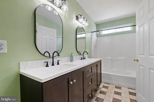 a bathroom with a double vanity sink and a mirror