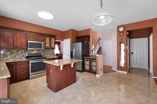 a kitchen with stainless steel appliances granite countertop a stove refrigerator and microwave