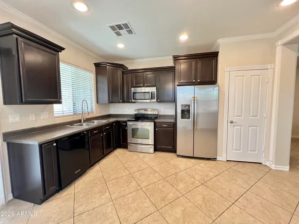 a kitchen with stainless steel appliances granite countertop a refrigerator a sink a stove a microwave and island