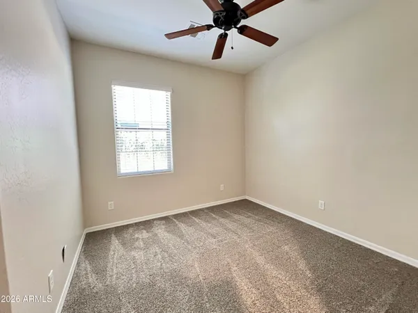an empty room with a window and a fan