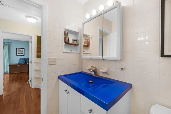 a view of a patio with table and chairs and floor to ceiling window with potted plants