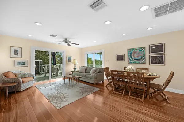 a living room with stainless steel appliances furniture and wooden floor