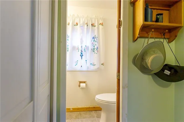 a bathroom with a toilet and a mirror