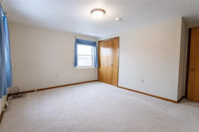 an empty room with a window and a ceiling fan