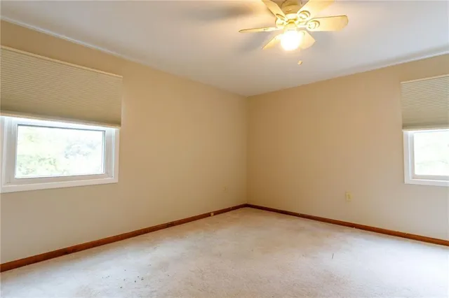 a view of an empty room and chandelier fan