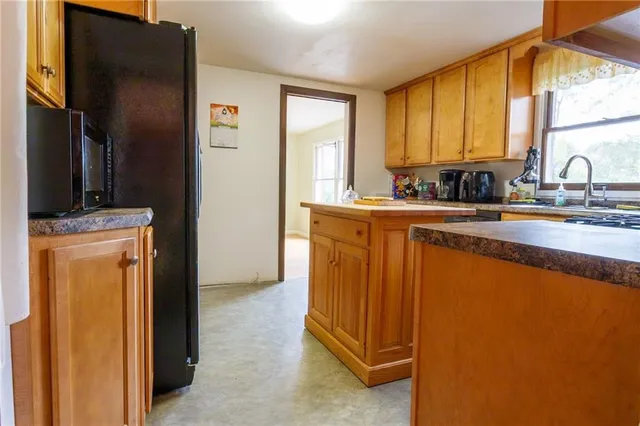 a kitchen with stainless steel appliances granite countertop a refrigerator a sink a stove and dishwasher