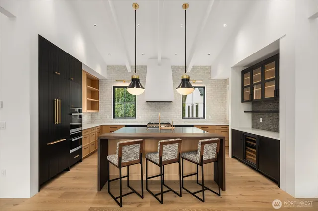 a kitchen with stainless steel appliances granite countertop a sink a stove and a wooden floors