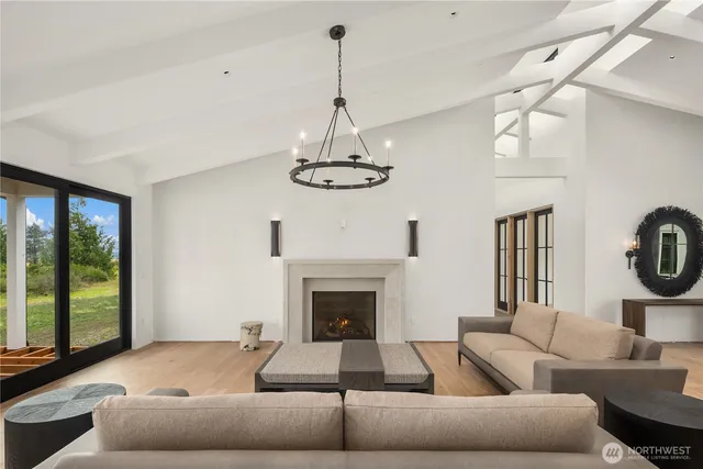 a living room with furniture a chandelier and a fireplace