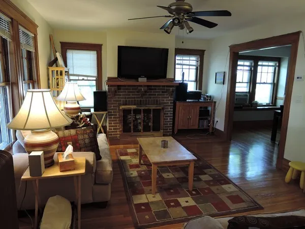 a living room with furniture a flat screen tv and a fireplace