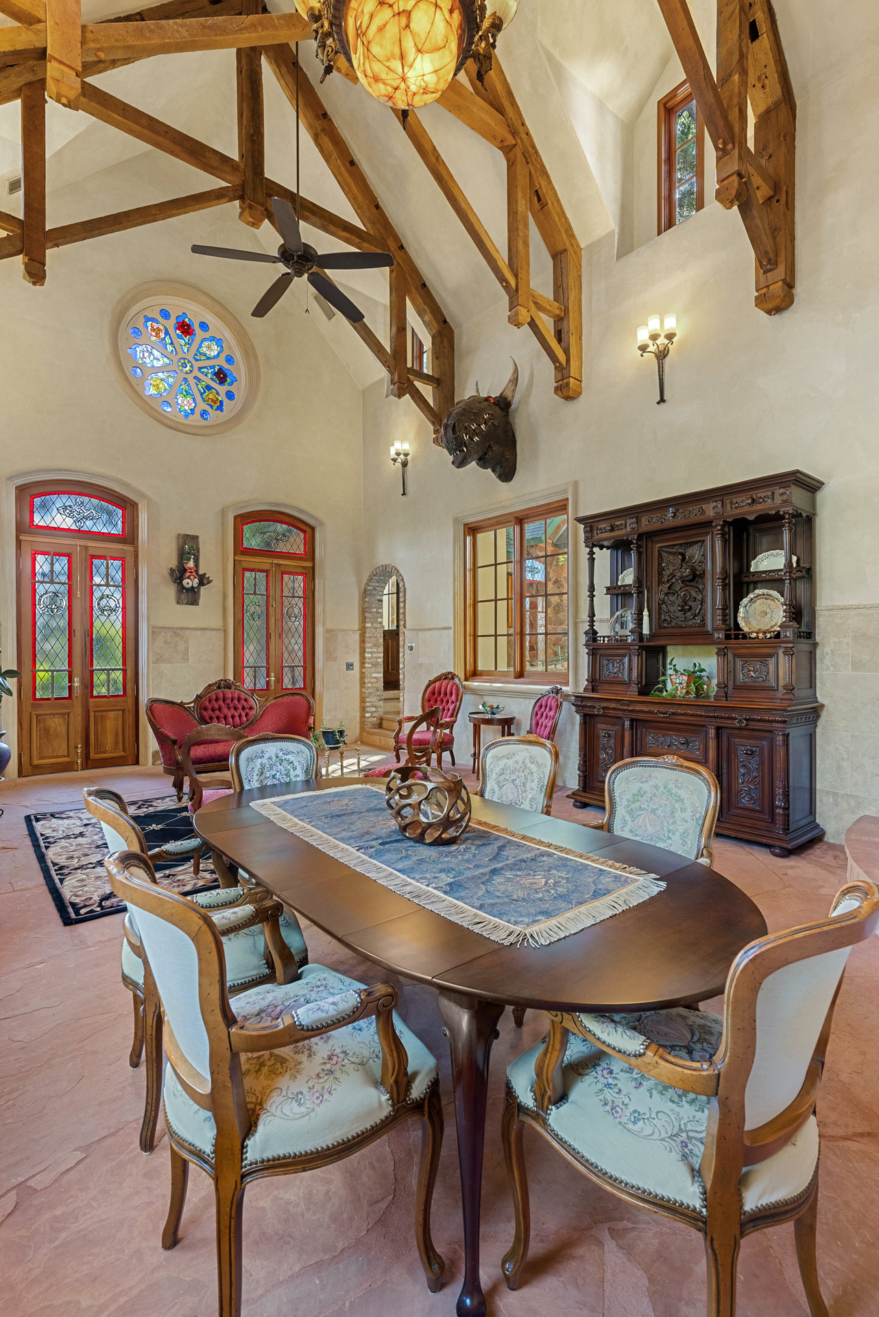 1354 The High Road Austin, TX 78746 - Photo 15 of 40 Ornate custom woodwork, exposed beam cathedral ceilings, and unique stained-glass windows define this formal dining space.