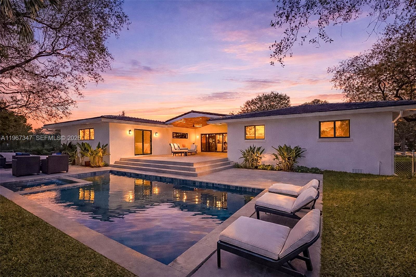a front view of a house with swimming pool table and chairs