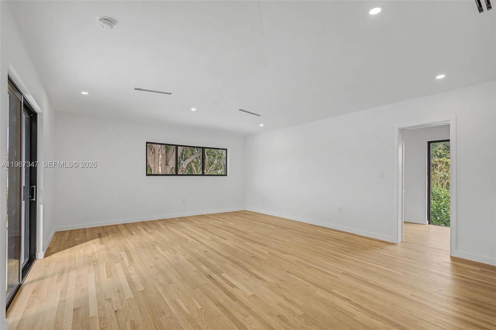12940 Southwest 73rd Avenue Pinecrest, FL 33156 - Photo 11 of 38 an empty room with wooden floor and windows