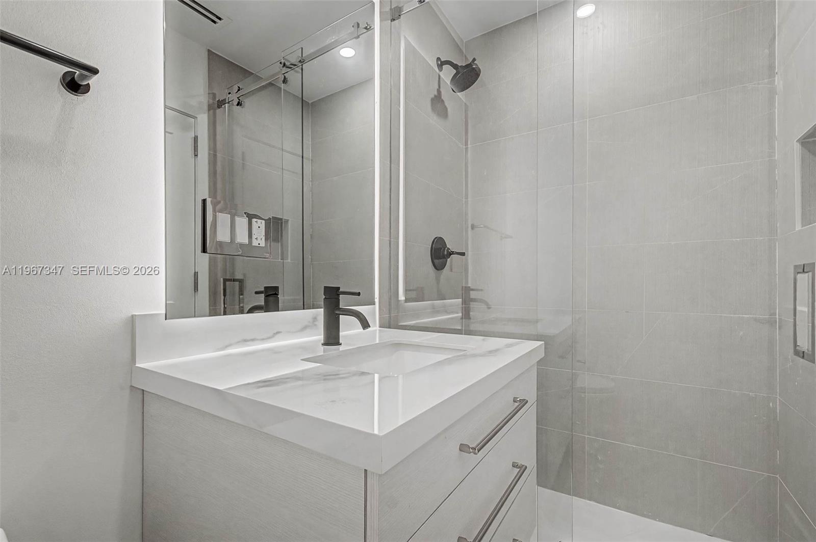 12940 Southwest 73rd Avenue Pinecrest, FL 33156 - Photo 27 of 38 a bathroom with a sink and a mirror