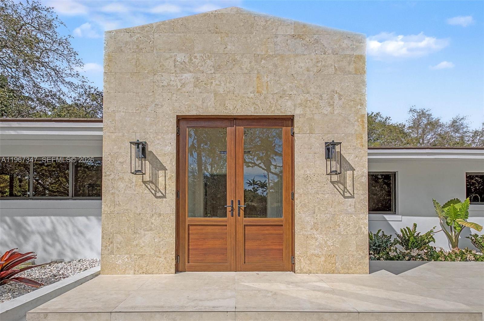 12940 Southwest 73rd Avenue Pinecrest, FL 33156 - Photo 3 of 38 a front view of a house with plants