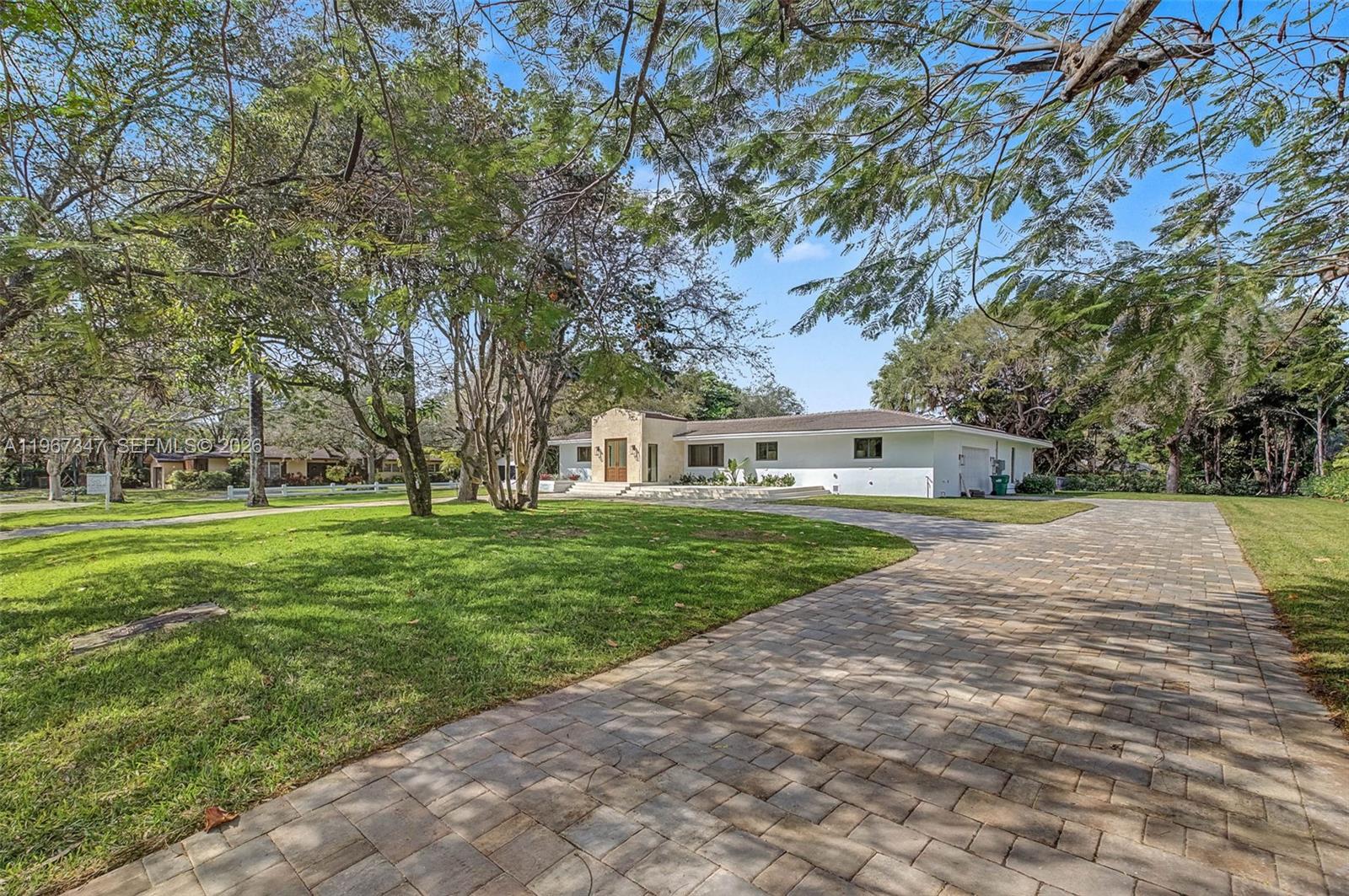 12940 Southwest 73rd Avenue Pinecrest, FL 33156 - Photo 35 of 38 a front view of a house with a garden