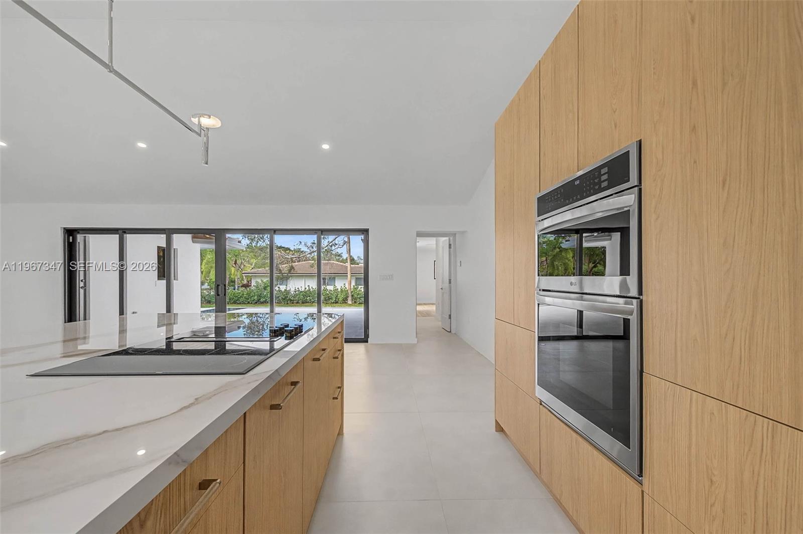 12940 Southwest 73rd Avenue Pinecrest, FL 33156 - Photo 7 of 38 a large white kitchen with a large window
