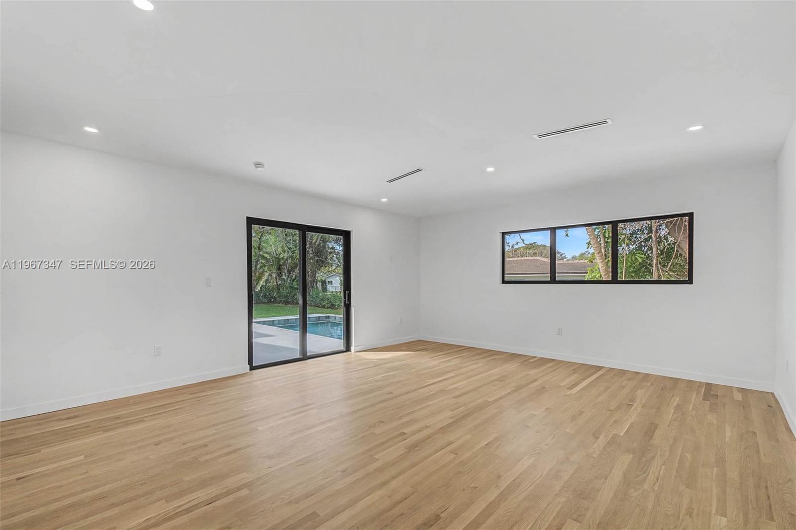 12940 Southwest 73rd Avenue Pinecrest, FL 33156 - Photo 10 of 38 a view of an empty room with wooden floor and a window