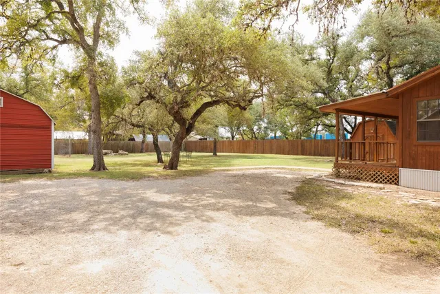 an empty room with wooden floor fireplace and windows