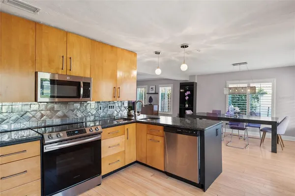 a kitchen with stainless steel appliances granite countertop a sink and a stove