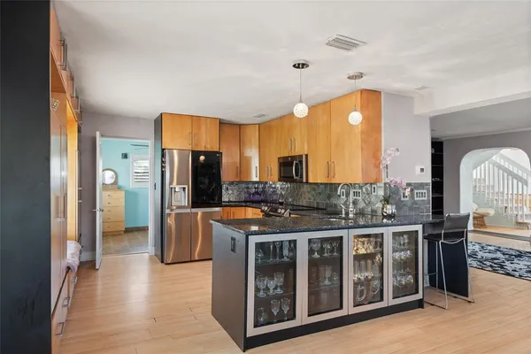 a kitchen with stainless steel appliances granite countertop a stove and cabinets