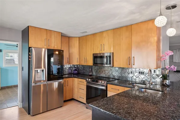 a kitchen with stainless steel appliances granite countertop a stove a sink and a refrigerator