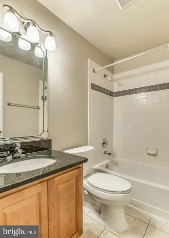 a bathroom with a granite countertop sink toilet a mirror and shower