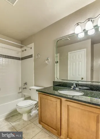 a bathroom with a granite countertop sink toilet a large mirror a bathtub and shower