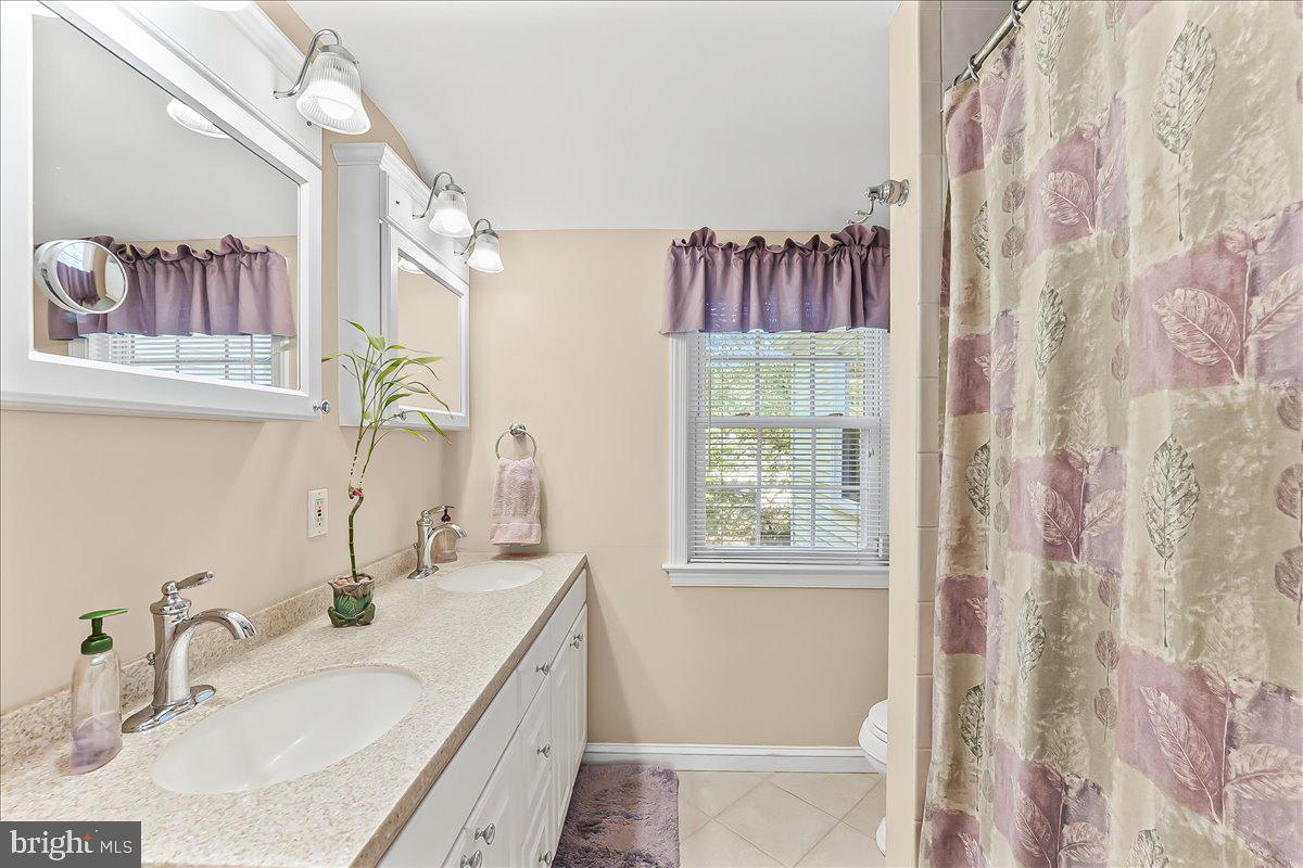 243 Rambling Way Springfield, PA 19064 - Photo 21 of 42 a bathroom with double vanity sink and a mirror