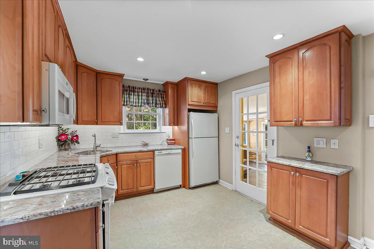 243 Rambling Way Springfield, PA 19064 - Photo 8 of 42 a kitchen with stainless steel appliances granite countertop a stove a sink dishwasher and a refrigerator