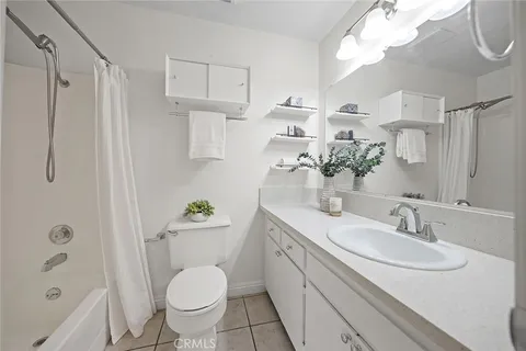 a bathroom with a granite countertop sink a toilet a mirror and shower