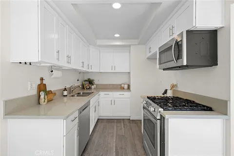 a kitchen with stainless steel appliances granite countertop a sink stove and microwave