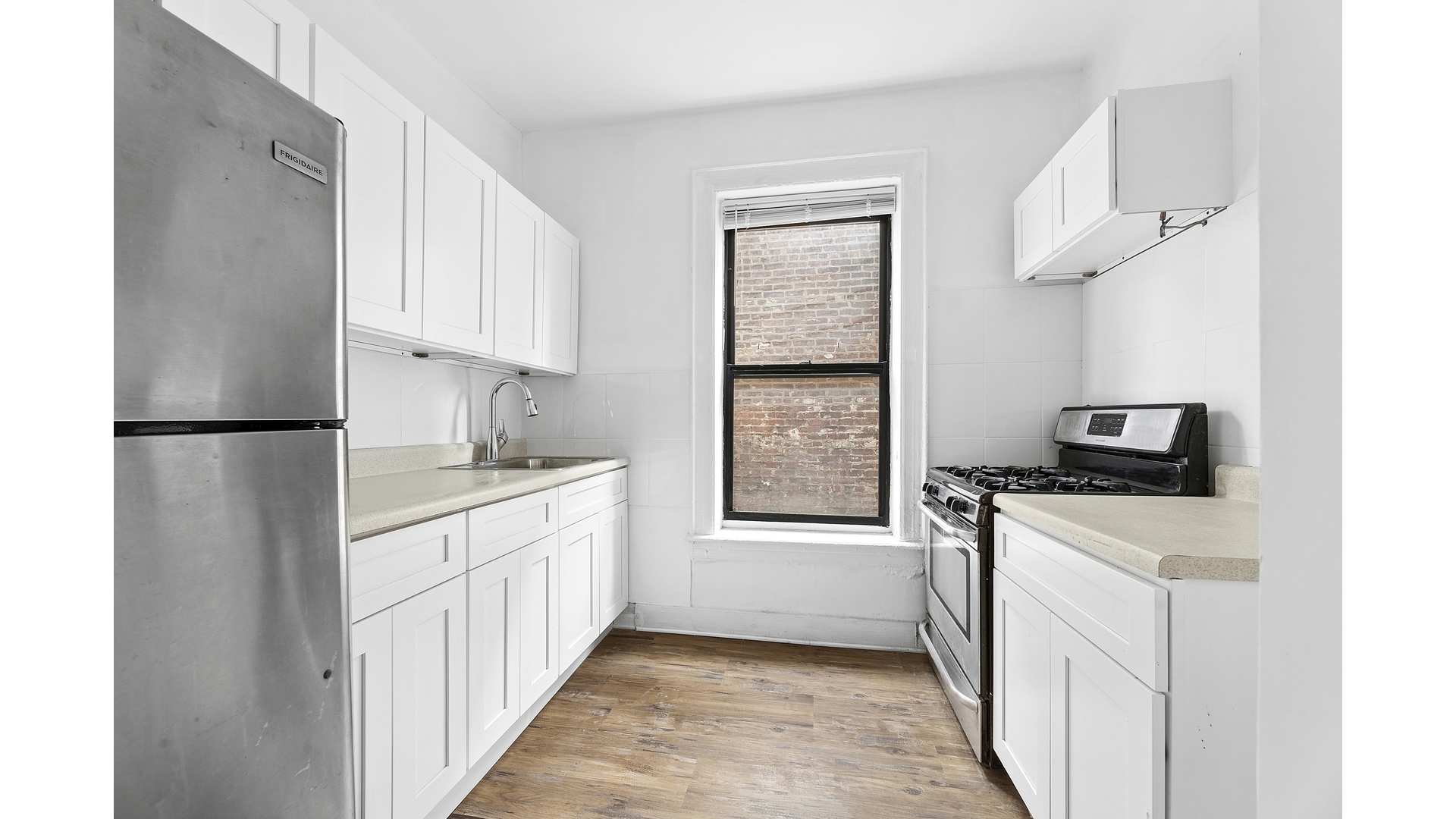 30 Macombs Place, Unit 54 Manhattan, NY 10039 - Photo 3 of 6 a kitchen with a stove a sink and a refrigerator