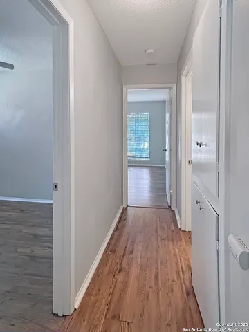 a view of a hallway with wooden floor