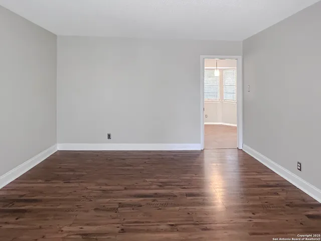 a view of a room with wooden floor and white walls