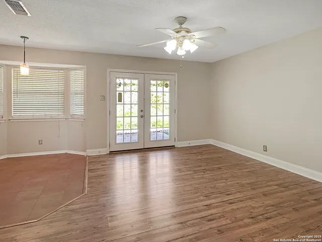 an empty room with wooden floor and window