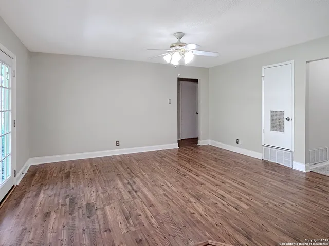 a view of a room with wooden floor and chandelier