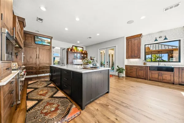 a kitchen with stainless steel appliances kitchen island granite countertop a stove and a sink