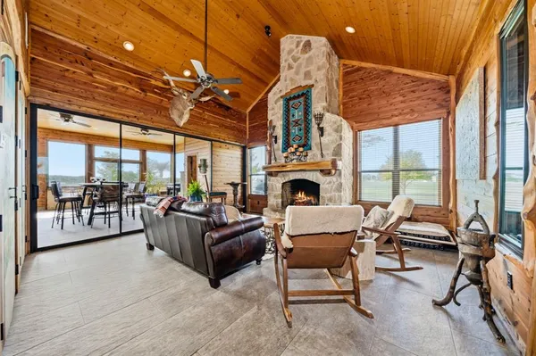 a living room with furniture a fireplace and a floor to ceiling window