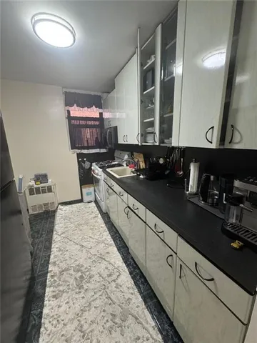 a kitchen with sink stove and cabinets