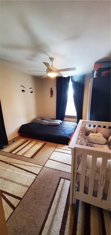 2400 East 3rd Street, Unit 317 Brooklyn, NY 11223 - Photo 7 of 8 a bedroom with a bed and a flat tv screen on the dresser