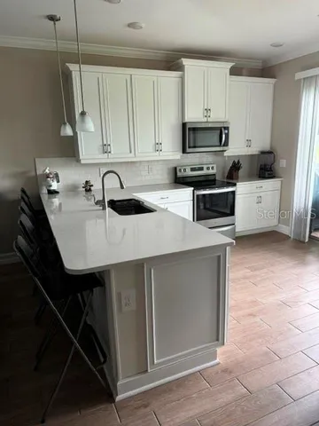 a kitchen with stainless steel appliances a sink a stove a microwave and cabinets