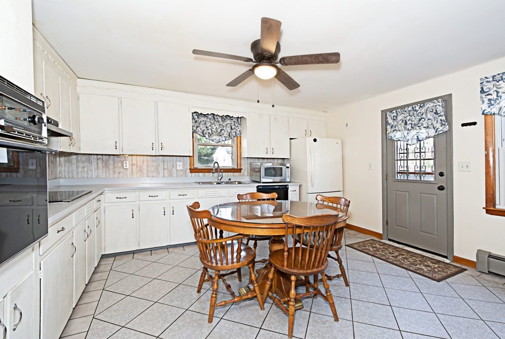 78 Lancaster Road Clinton, MA 01510 - Photo 8 of 29 a kitchen with stainless steel appliances granite countertop a sink a stove a dining table and chairs with wooden floor