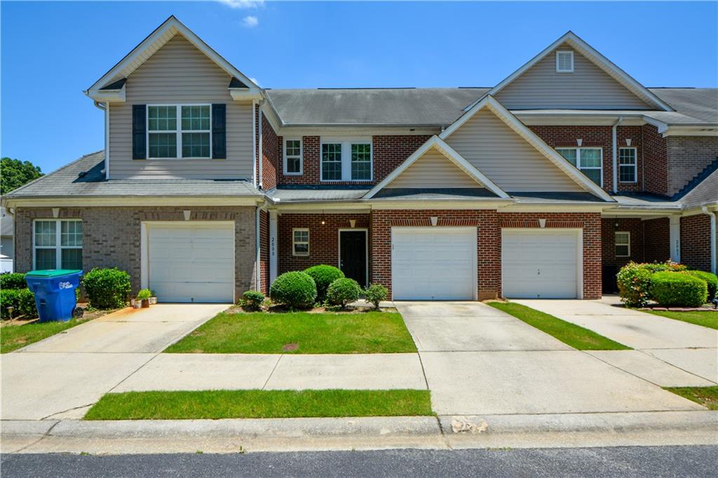 2555 Flat Shoals Road, Unit 2008 Atlanta, GA 30349 - Photo 1 of 33 a front view of a house with a yard and garage
