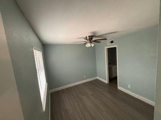 301 Rolston Road, Unit 303104 Irving, TX 75060 - Photo 7 of 8 Spacious room featuring wood-finish flooring, light blue wall paint, white baseboards, and a ceiling fan with integrated lighting