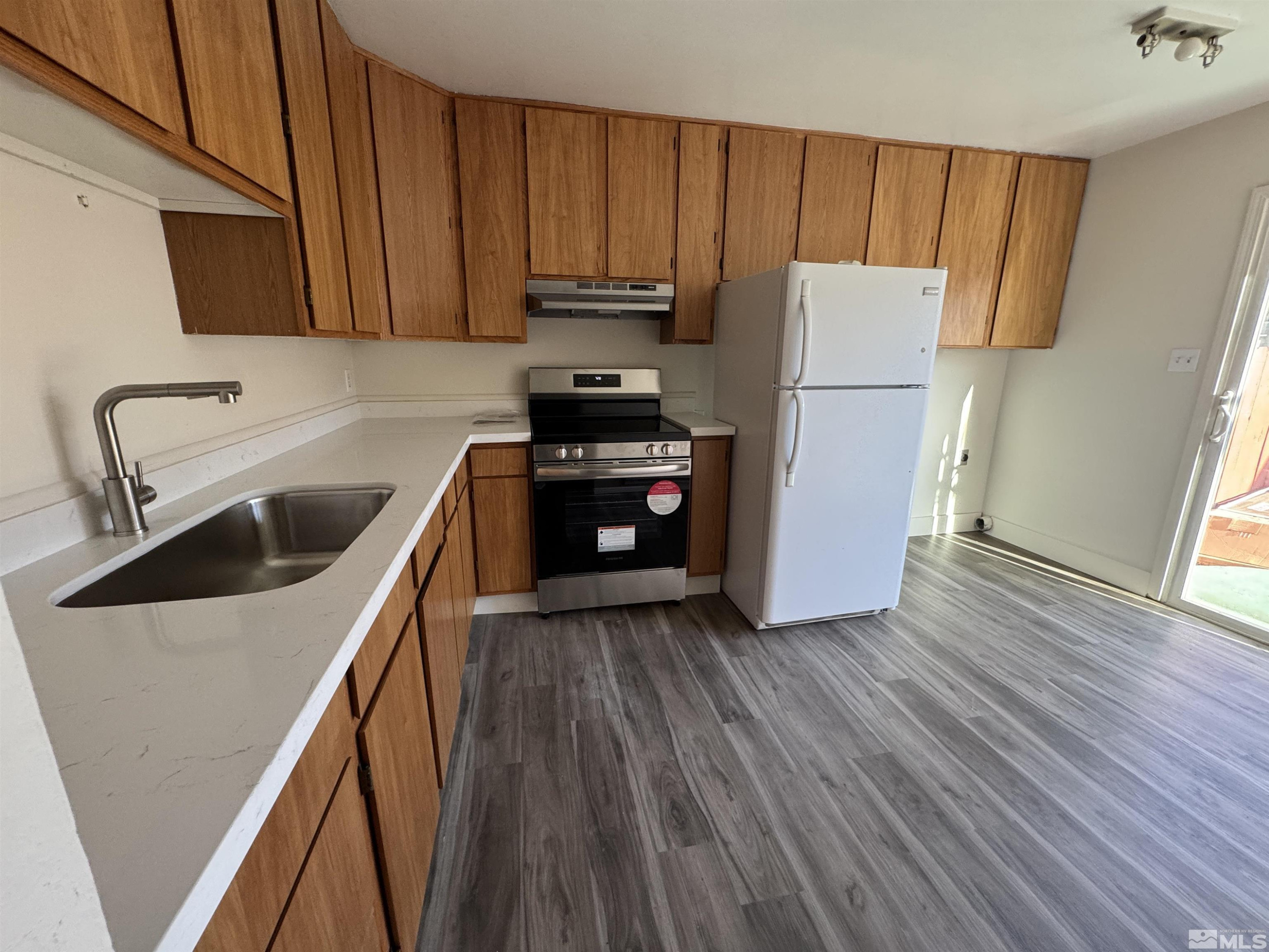 445 Pine Meadows Drive, Unit 29 Sparks, NV 89431 - Photo 5 of 13 a kitchen with wooden cabinets and white appliances