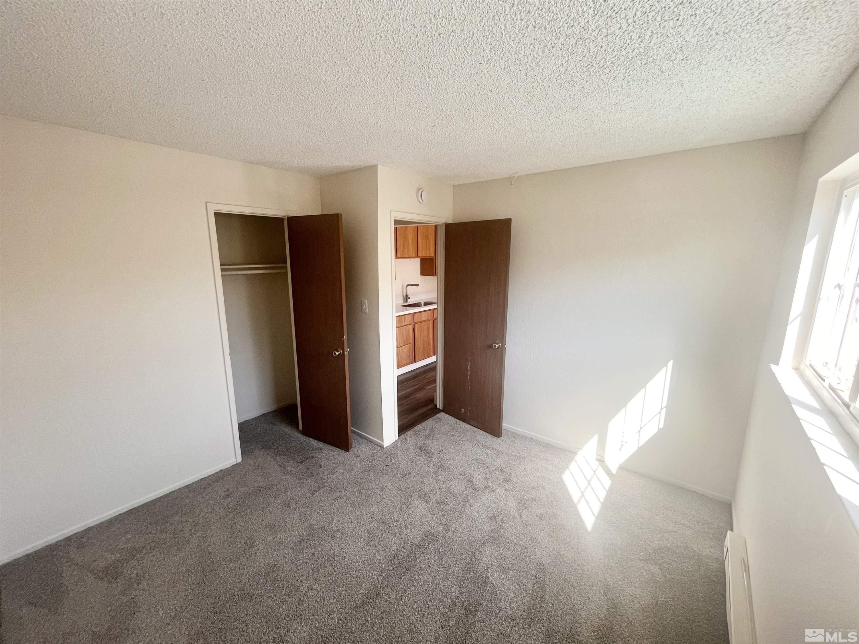 445 Pine Meadows Drive, Unit 29 Sparks, NV 89431 - Photo 7 of 13 an empty room with windows and closet