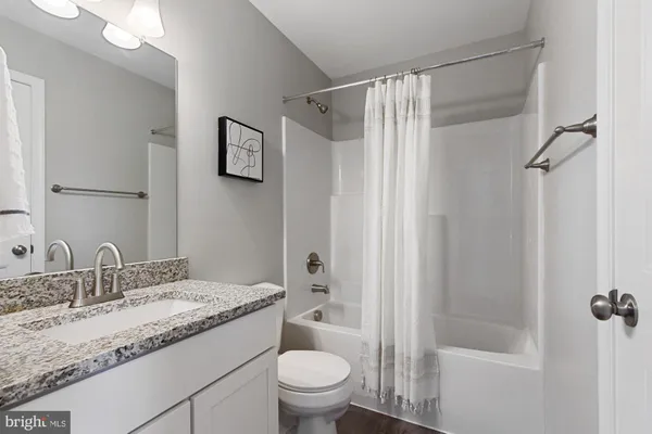 a bathroom with a granite countertop sink toilet and shower glass cabinet